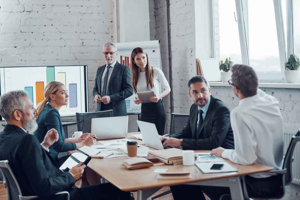 Business Professionals Presenting Analytical Report While Working Together